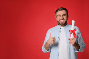 Wall Mural - Happy student with diploma on red background. Space for text