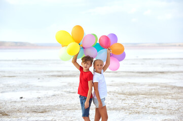 Funny kids with colorful balloons in the fresh air