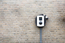 New Charging Station For Electric Car On Brick Wall At Home, Charging Pillar With Copy Space ,