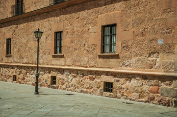 Wall Mural - Deserted alley with old gothic building made of stone and public lamp at Salamanca. One of the most important university cities in Spain.