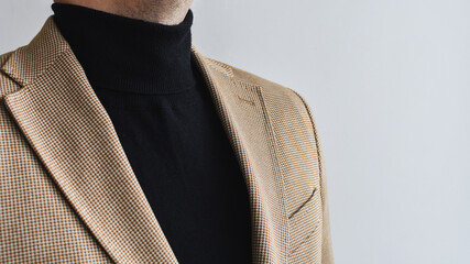 Wall Mural - Detail of men outwear, fashionable mens black sweater combined with light beige blazer. Selective focus.