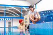 © Marcos - latin swimming woman coach talking some advices to young disabled man in pool in disability concept with hand hypoplasia