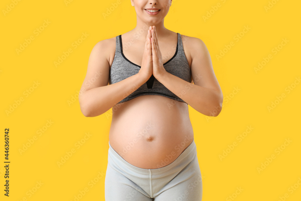 Young pregnant woman meditating on color background