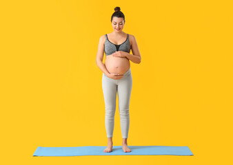 Wall Mural - Young pregnant woman on color background