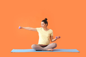 Poster - Young pregnant woman with dumbbells training on color background