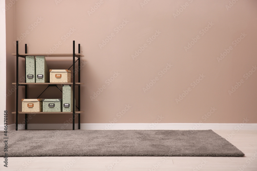 Room with soft grey carpet, shelving rack and pale brown wall. Space for text - obrazy, fototapety, plakaty 