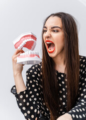 Wall Mural - Beautiful young woman with plastic teeth. Oral special equipment.