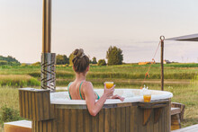 Woman Enjoy Outside Ofuro Japanese Hot Tub In Romantic Nature Environment. Idyllic Bathtub In Sunset
