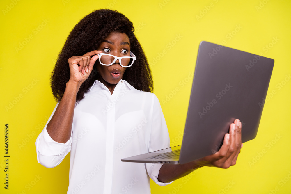 Photo portrait of business woman amazed using laptop taking off glasses isolated bright yellow color background - obrazy, fototapety, plakaty 