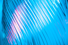 Abstract Glass Background. Texture Of Wavy Glass Illuminated With Multi-colored Light. Pink And Blue Stains. Glass Flares. Close Up.