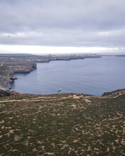 Aerial View Of A Lone Boat Along The Wild Coastal In Sagres At S