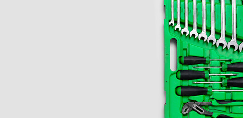 Wall Mural - Green set of construction tools: wrenches, adjustable pliers, screwdriver and so on on white background. Banner with place for text for a hardware store. Metal hardware for professional repair or DIY