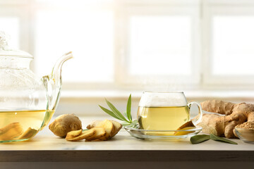 Poster - Cup with ginger drink and sliced root on kitchen bench