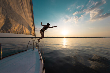 Wall Mural - Girl jumping into the water from a yacht