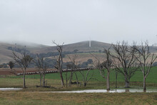 Rural View Of Wind Turbines Under Low Cloud On The Hillside