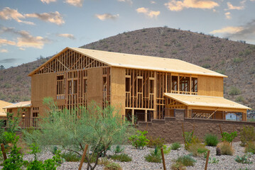 New residential construction home framing against a blue sky