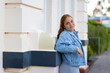 © Austockphoto - young lady in denim jacket with back to wall looking at camera