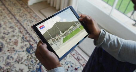 Canvas Print - Composite of man sitting at home, watching athletics high jump event on tablet