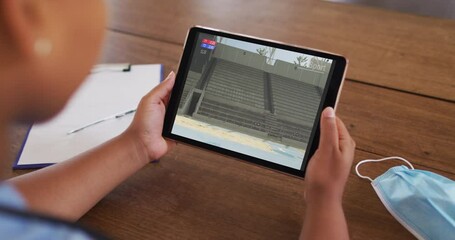 Poster - Composite of woman sitting at table with face mask, watching athletics long jump event on tablet