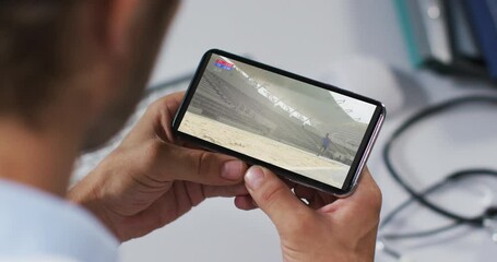 Poster - Composite of male doctor watching athletics long jump event on smartphone