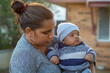 © Austockphoto - Young mother holding her baby outside