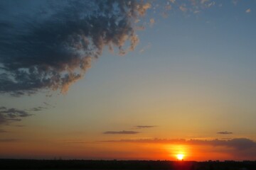 Wall Mural - Beautiful sunset over the field,  the sun sets over the horizon