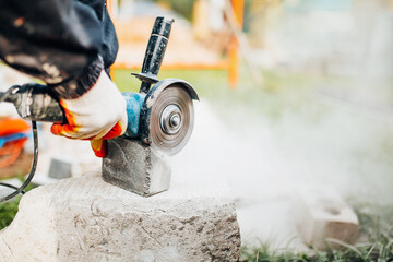 Wall Mural - Dust from the work of a diamond blade on an angle cut-off machine - the work of a tiler on paving stones