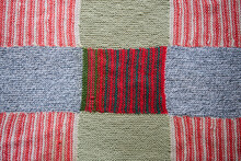 Colored Knitted Blanket Made Of Wool Yarn In Stripes And Rectangles For Home Design.