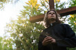 © M-Production - Christian priest with cross on the cemetery.