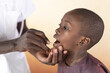 Mouth test swab for detecting coronavirus. Health examination to African black boy by African doctor.