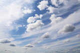 Fototapeta Niebo - Blue sky covered with white cumulus and cirrus clouds. Summer cloudscape, beautiful weather background