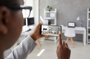 black designer taking office interior photos, making presentation or video calling client using smar