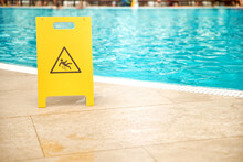 Warning Plates Wet Floor Beside The Pool Made Of Yellow Plastic.