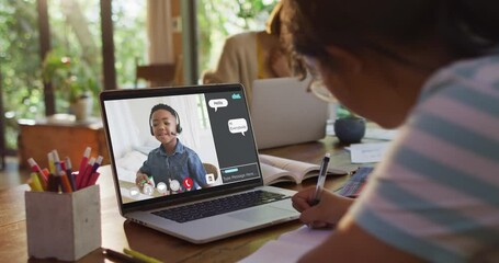 Wall Mural - Schoolgirl using laptop for online lesson at home, with boy talking and web chat on screen