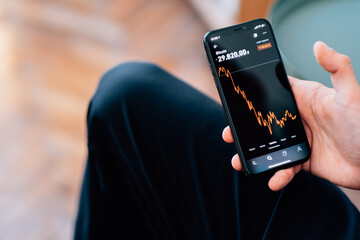 Poster - Man using his smartphone to check the crypto-trading platform