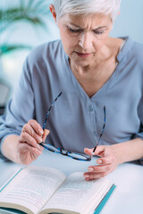 Wall Mural - Senior Woman a Reading Book. Vision Loss Problems.