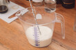 Milk in a measuring cup on the kitchen table