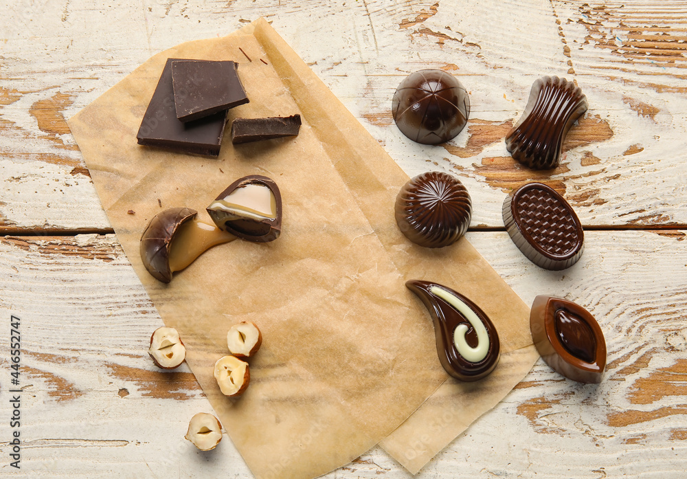 Sweet chocolate candies with nuts on white wooden background