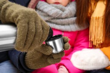 Canvas Print - Happy family drinking hot tea outdoors on winter day, closeup