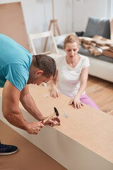 Wall Mural - Husband and wife assembling new furniture - renovation home concept.