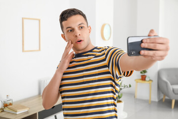 Poster - Surprised young man taking selfie at home