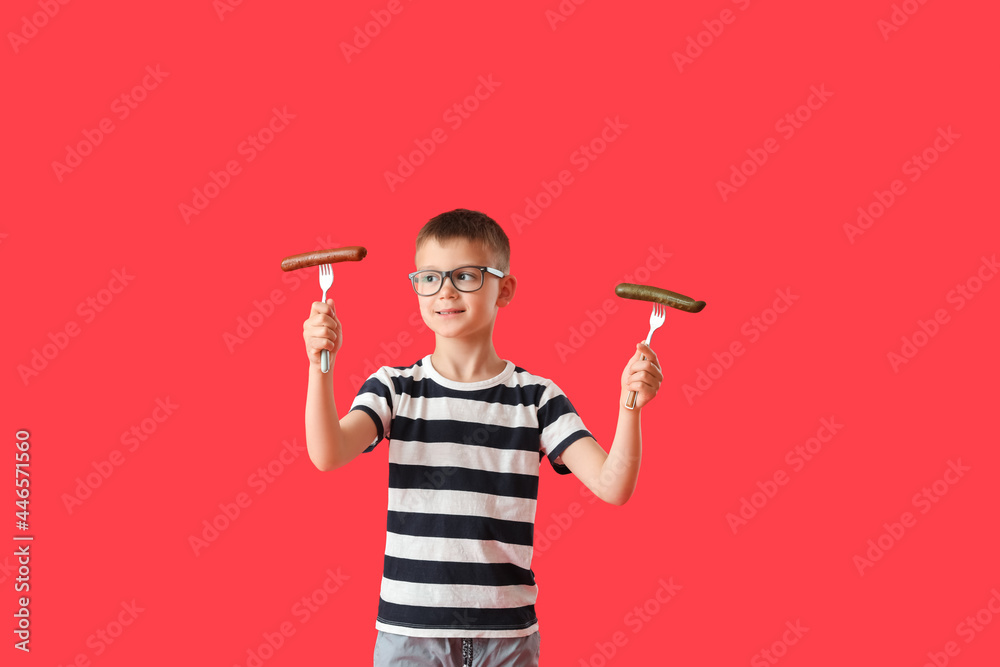 Little boy with tasty sausages on color background