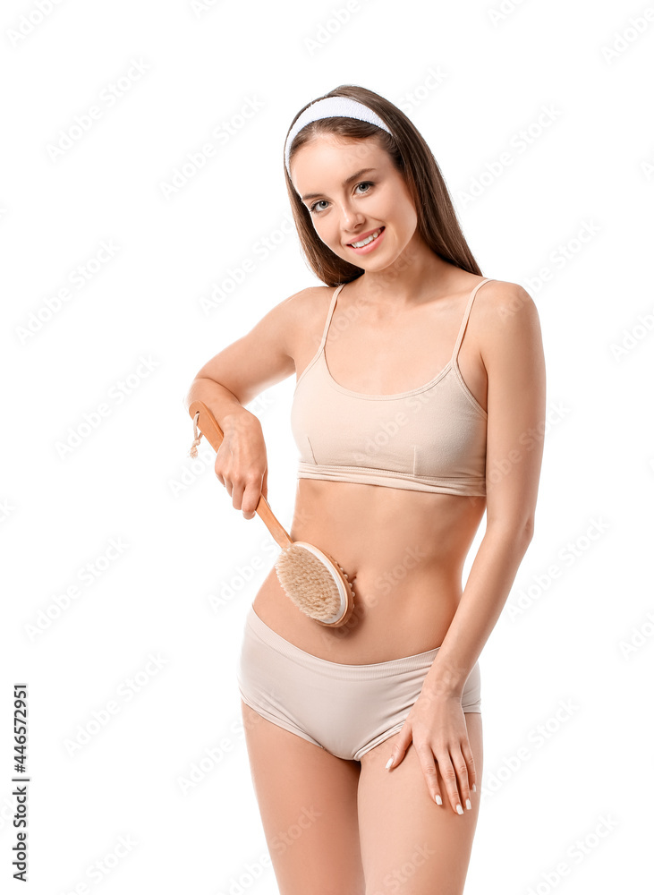 Beautiful young woman with massage brush on white background