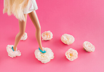 Wall Mural - Girl with blue shoes on white roses on a pastel pink background. Creative minimal fashion concept.