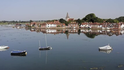 Wall Mural - Bosham Village and estuary with small boats and English cottages reflecting in the water. Aerial footage.