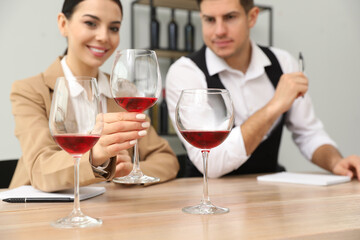 Canvas Print - Sommeliers tasting different sorts of wine at table indoors