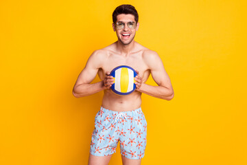 Sticker - Photo of impressed brunet young guy with ball wear eyewear shorts isolated on yellow background