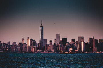 Fototapete - New York City Manhattan downtown skyline at dusk with skyscrapers illuminated over Hudson River panorama.