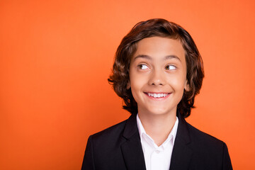 Sticker - Photo of young happy dreamy charming boy look empty space curious good mood isolated on orange color background