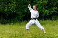 Teenage Girl Training Karate Kata Outdoors, Performs Age-uke (rising Or Upward Block)